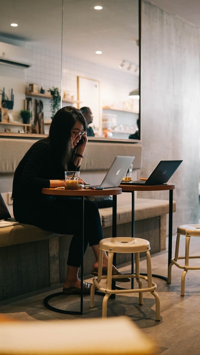穿黑色长袖衬衫的女士使用macbook